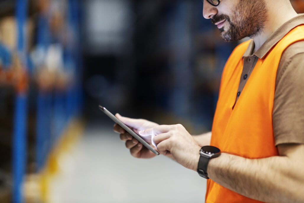 Close up of a warehouse worker using EPR on tablet