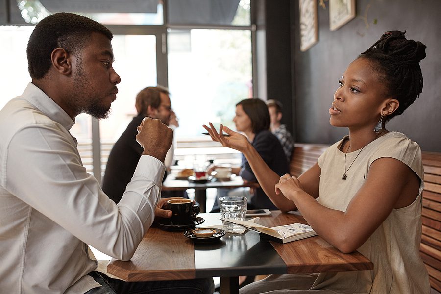 Two business professionals having a focused conversation over coffee in a casual setting, emphasizing the power of face-to-face networking and building personal connections, as discussed in local networking groups like BNI.